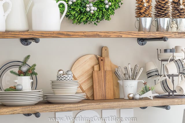 Dishes and cutlery are on the open shelves in the kitchen.