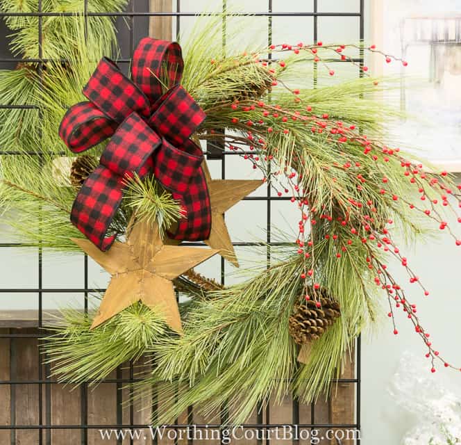 Stars added to a wispy wreath with a buffalo checked ribbon bow.