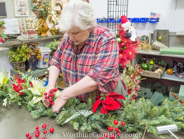 A green garland with pops of red flowers and berries.