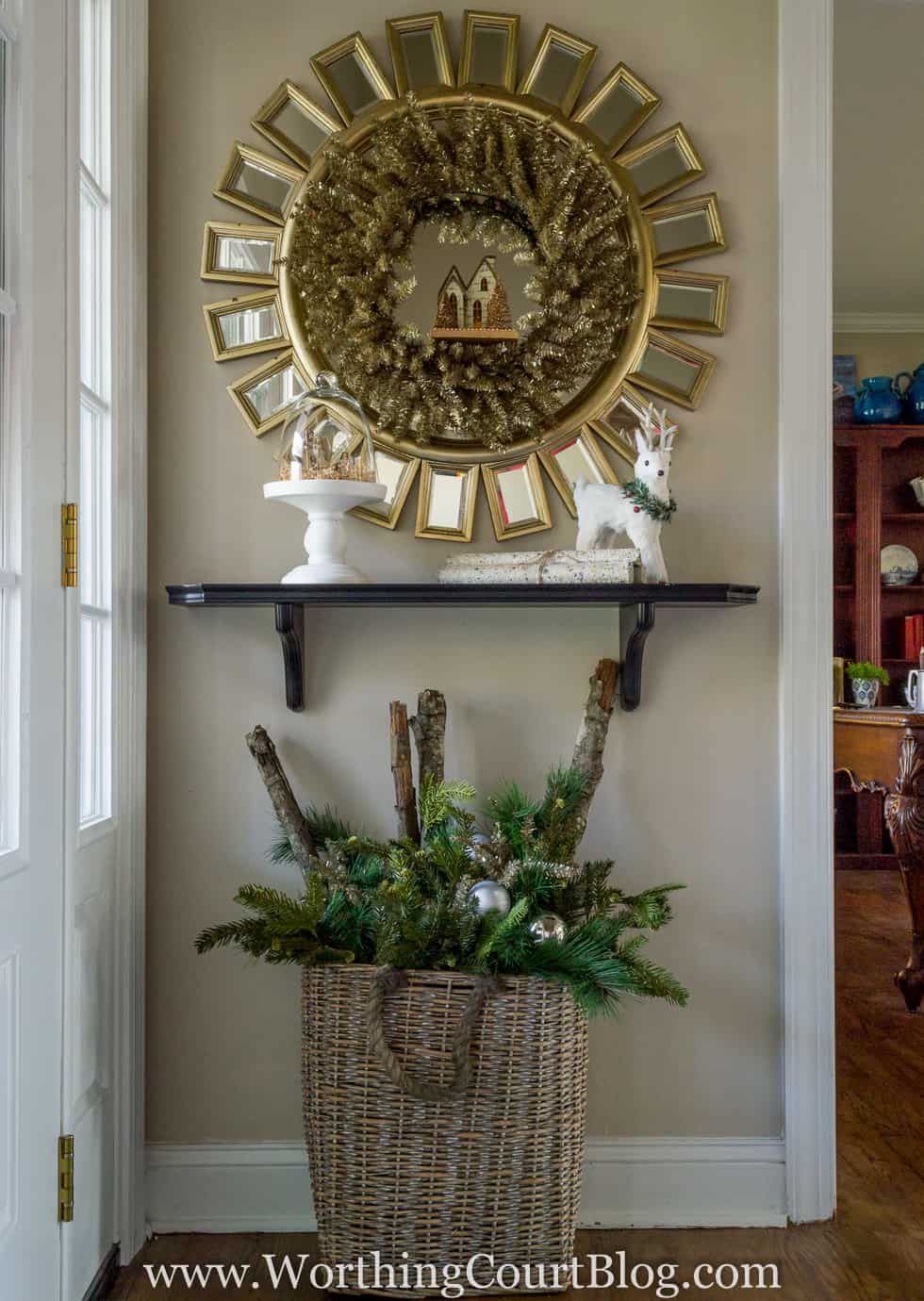 A starburst mirror above a small shelf in the foyer.