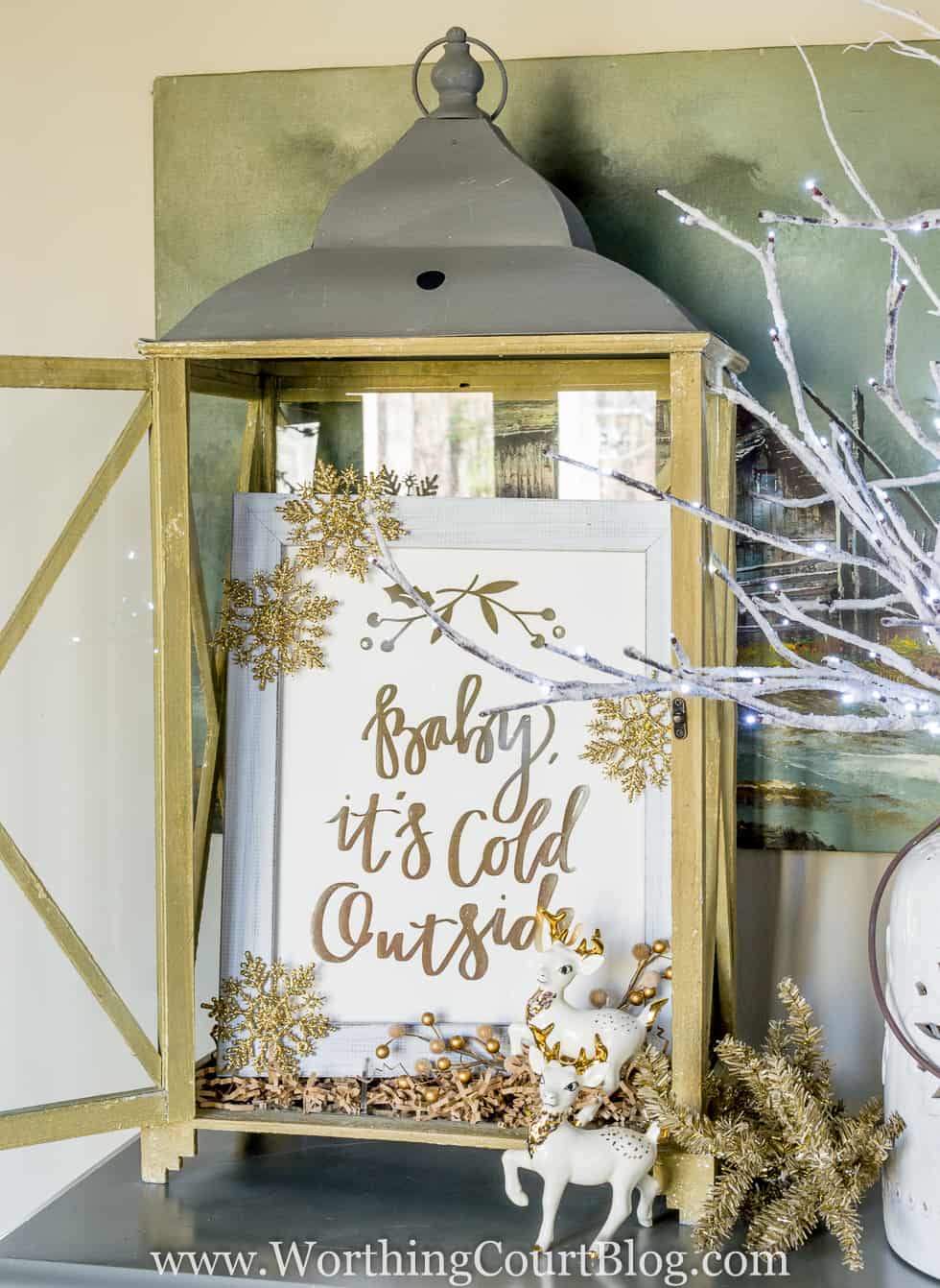 'Baby It's Cold Outside' gold foil print from Minted displayed in a rustic lantern