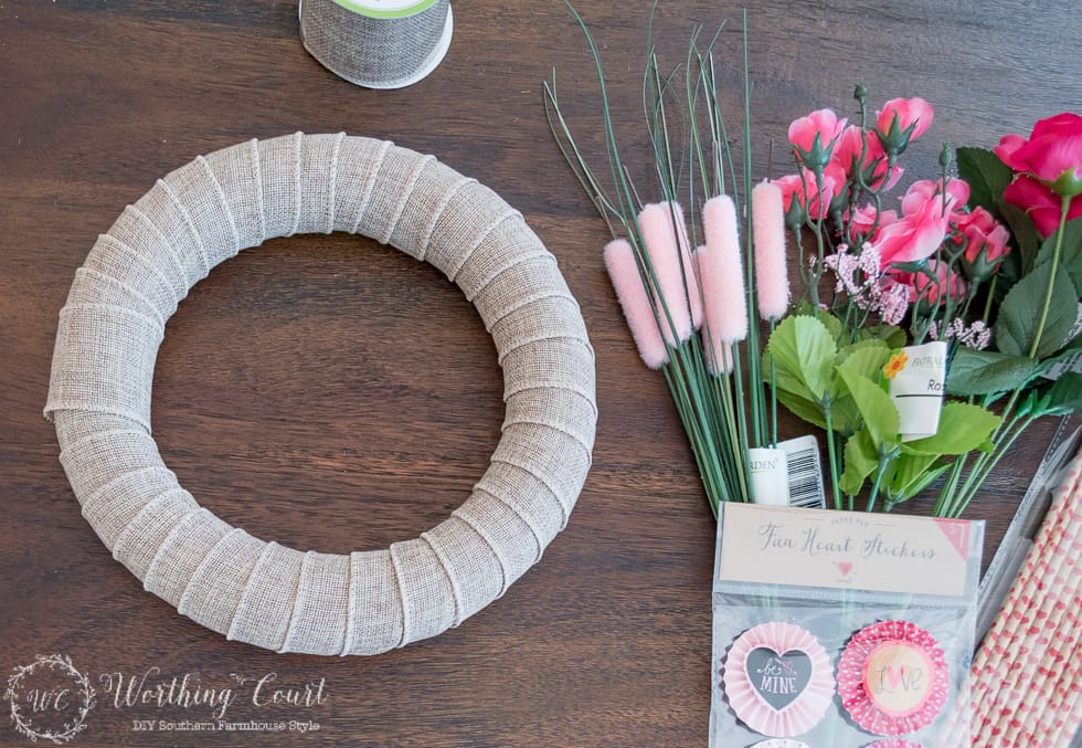 To make a Valentine's Day wreath, wrap the wreath form with burlap ribbon