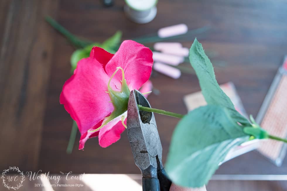 Snip the stems from the flowers in preparation for adding them to the Valentine's Day wreath