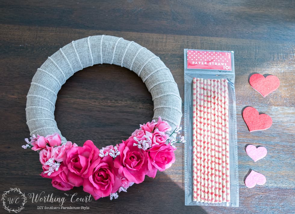 Attaching the flowers to the burlap wreath with a hot glue gun.