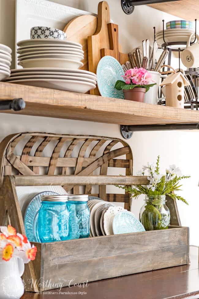 A wooden box with plates and spring items.