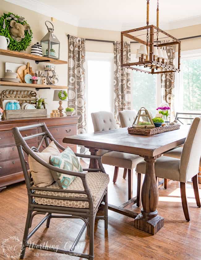 A wooden dining room chair with throw pillows on the chair.