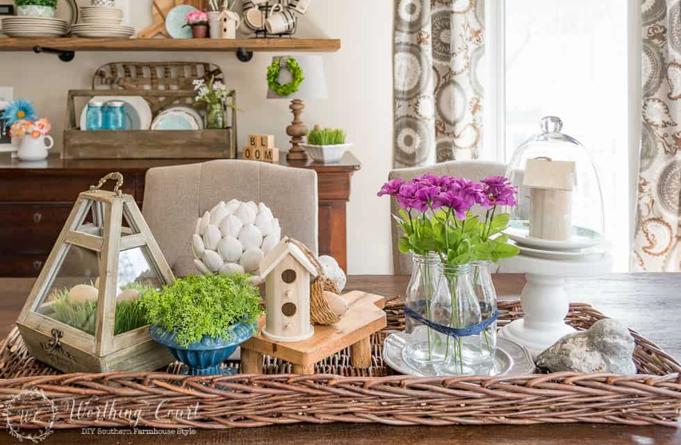 Farmhouse kitchen table spring centerpiece with pinky purple flowers and greenery.