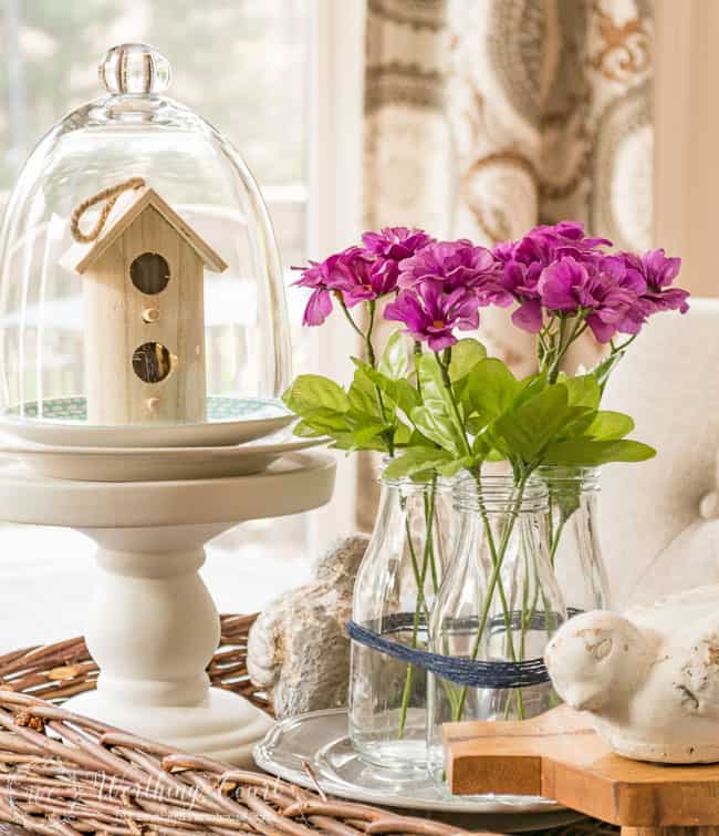 Farmhouse kitchen table spring centerpiece with the flowers in a clear glass vase.