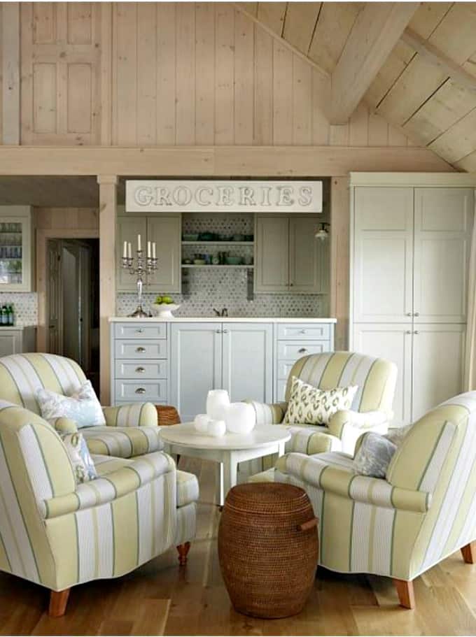 Four armchairs around a round table with a wicker basket beside it.