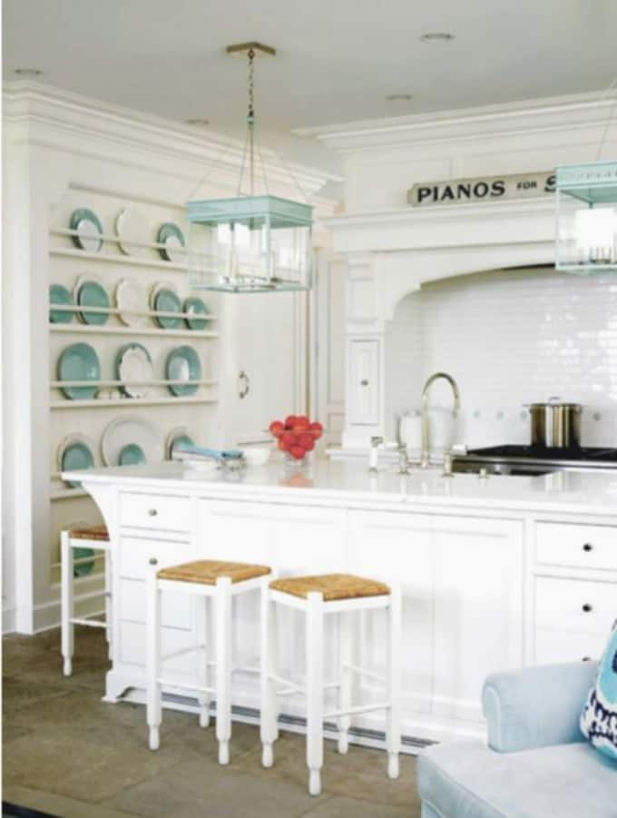 A rack that takes up the whole wall with blue and white plates on it in the kitchen.