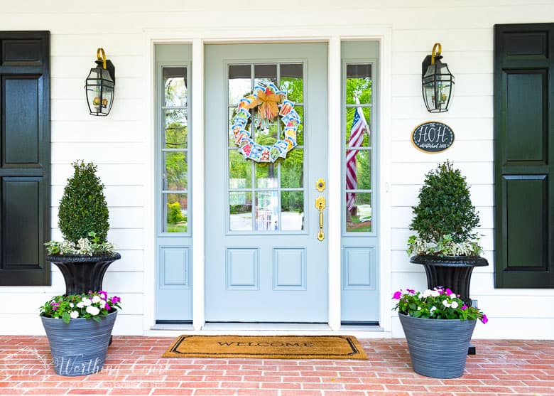 Farmhouse style front porch and easy containers with a welcome mat.