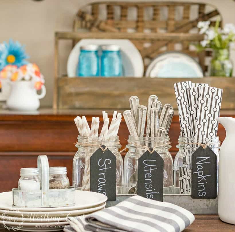 Up close picture of the mason jars holding utensils, napkins and straws.