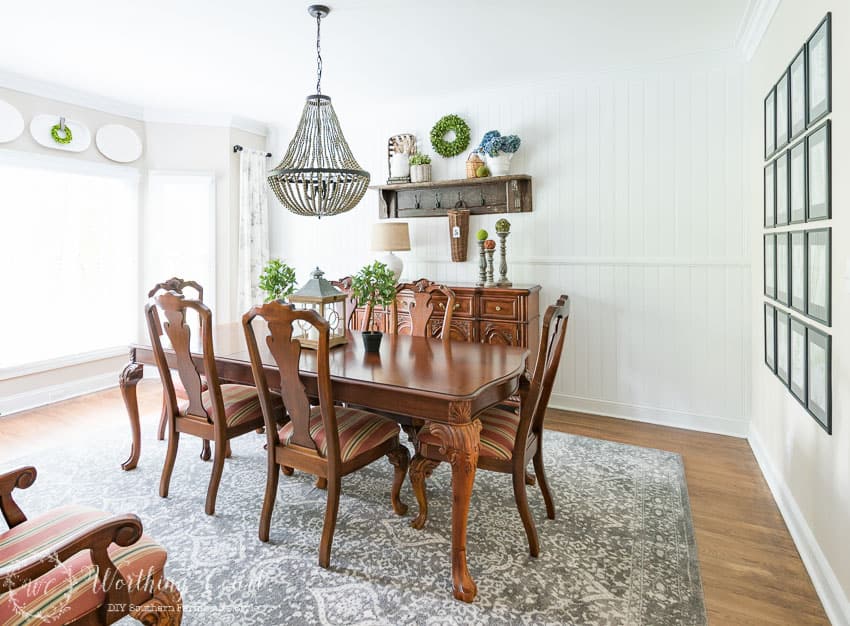 There is a wooden shelf on the wall behind the table.