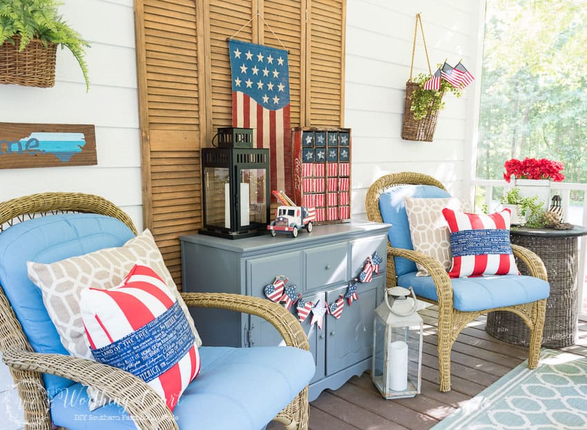 A farmhouse porch filled with loads of red, white and blue vintage Americana patriotic decorating ideas for Memorial Day, Flag Day and July 4th.