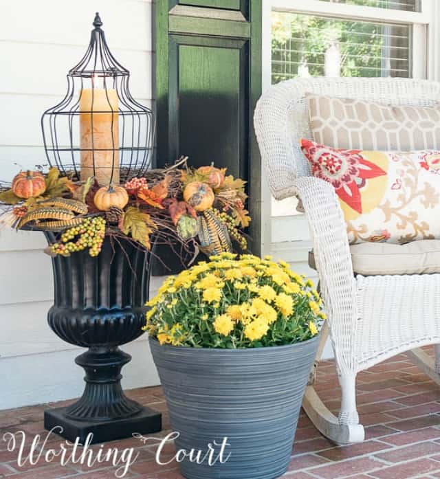 A black urn filled with autumn decor.