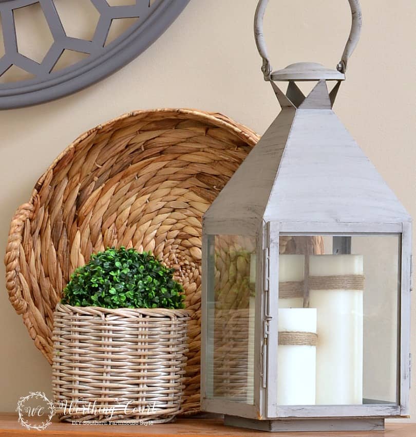 large gray lantern filled with a trio of white candles