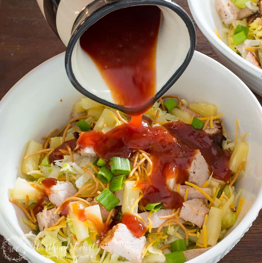 Pouring the sweet BBQ sauce over the salad.