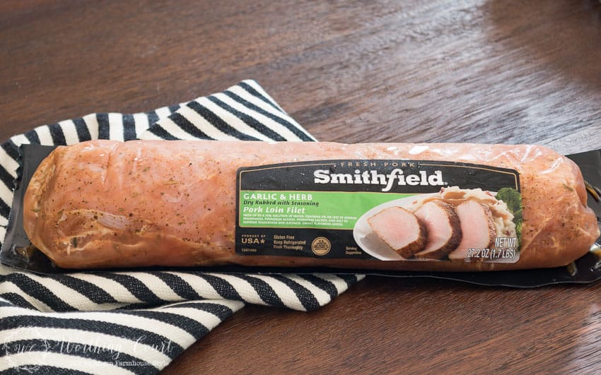 A pork loin in its package on the counter.