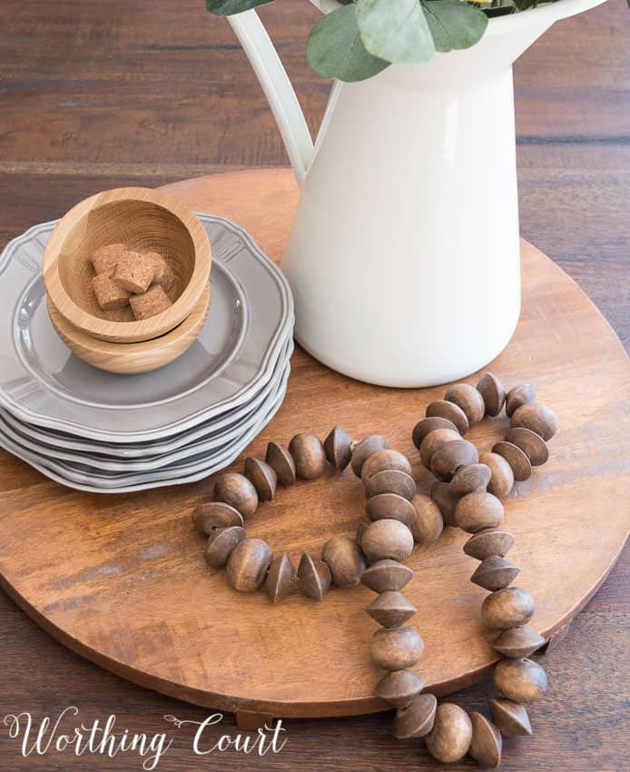 A wooden cutting board and a pitcher with the centerpiece.