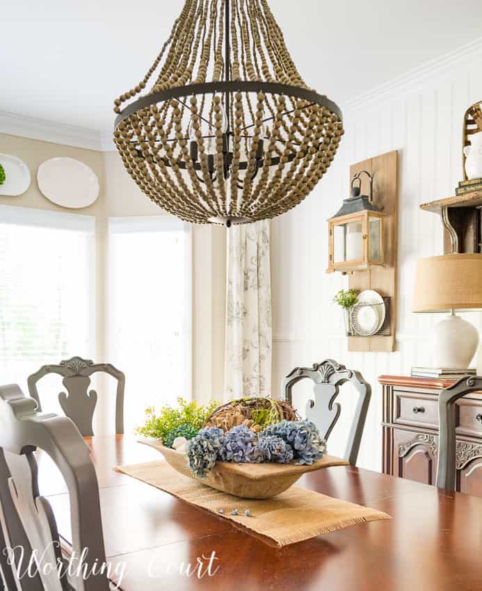 Wooden dough bowl centerpiece filled with spring decor.