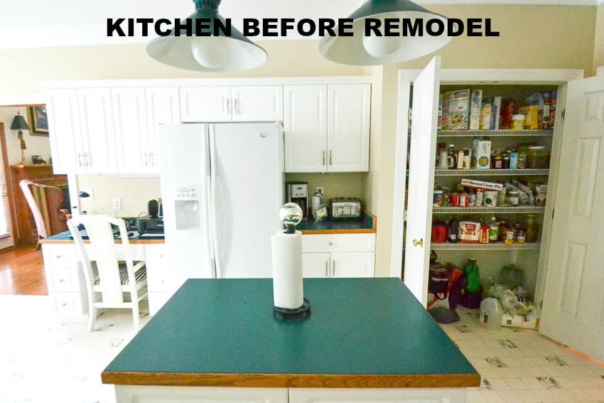 A green kitchen island and pantry door open.