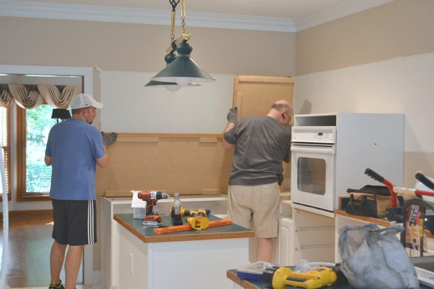 Kitchen cabinet demo with two men removing the cabinets.