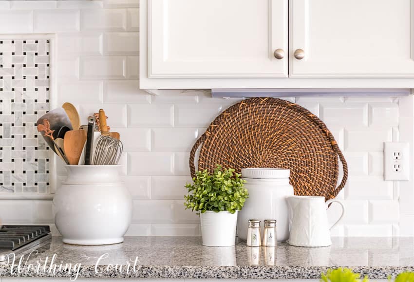 Farmhouse kitchen vignette with a white container and utensils in it.