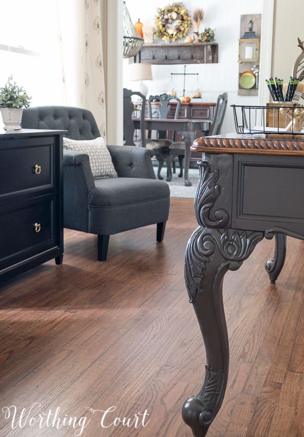 Office desk legs painted gray plus a gray armchair in the corner of the room.