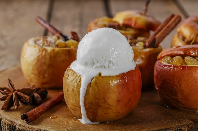 A baked apple with a dollop of ice cream on top.