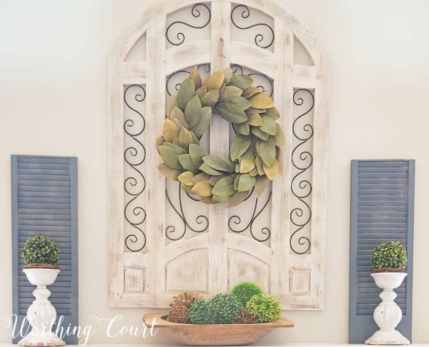 Simple spring mantel decor with a wreath hanging above the mantel.