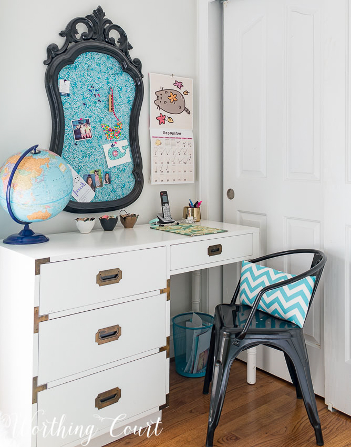 colorful teenage girls bedroom with a pink headboard, furniture painted white, teal lamp shades, teal throw, brass trunk, tissue paper garland and a gallery wall