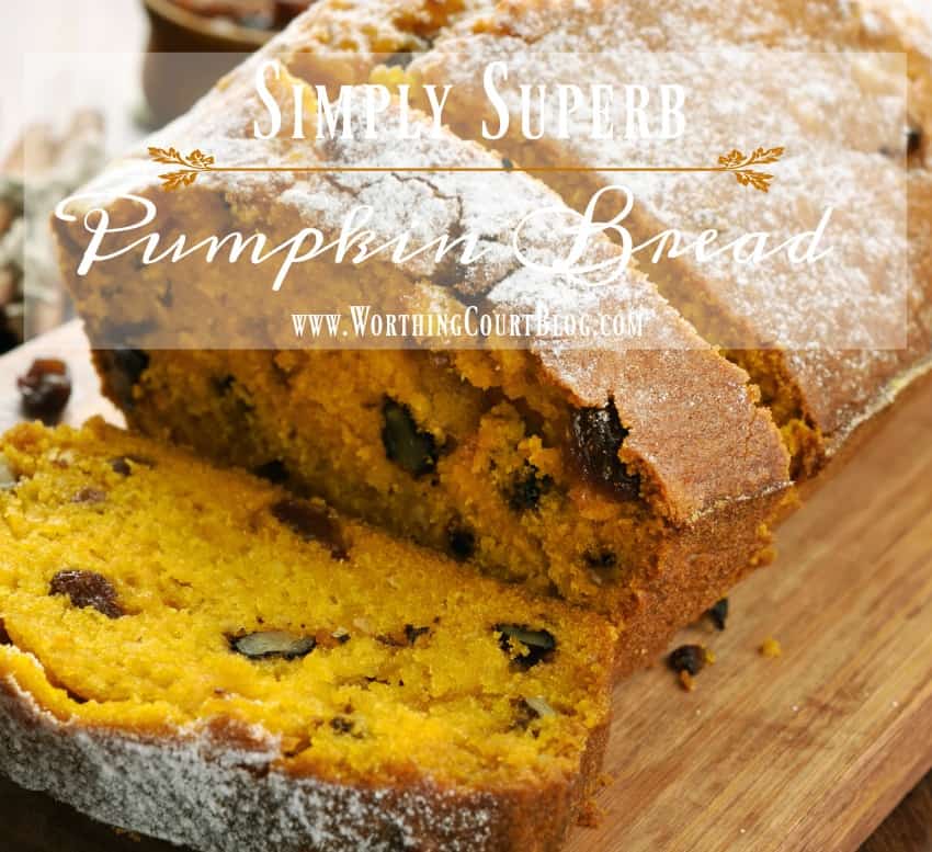 The pumpkin bread on a wooden board with one sliced.