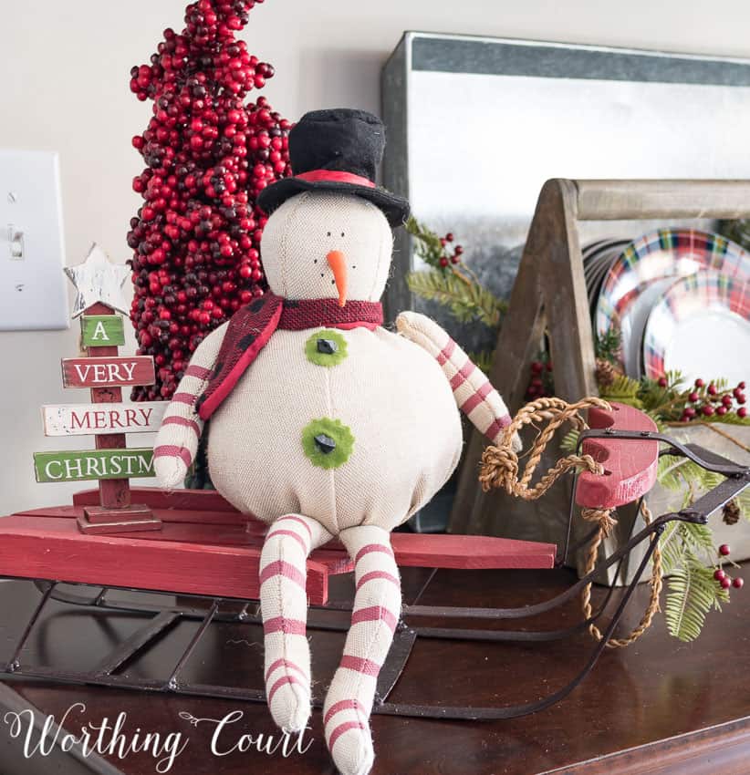 Christmas vignette with a primitive snowman and sled.