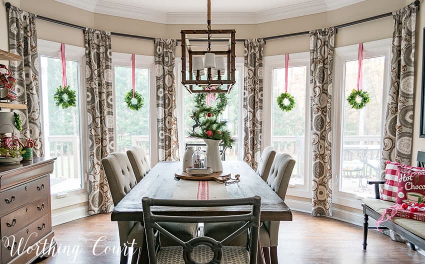 Christmas breakfast nook with wreaths in the bay windows.