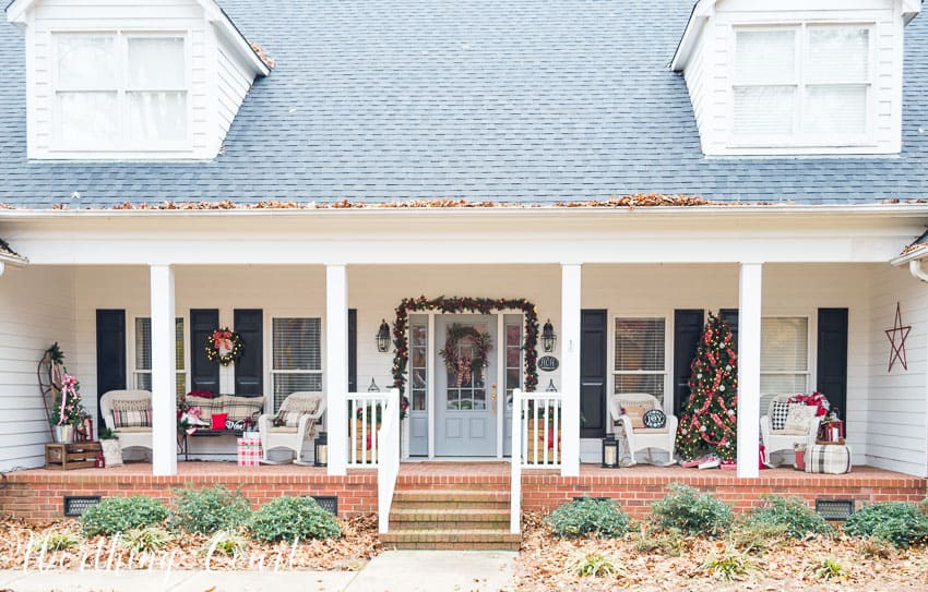 A large urban covered porch decorated in the farmhouse theme for Christmas.