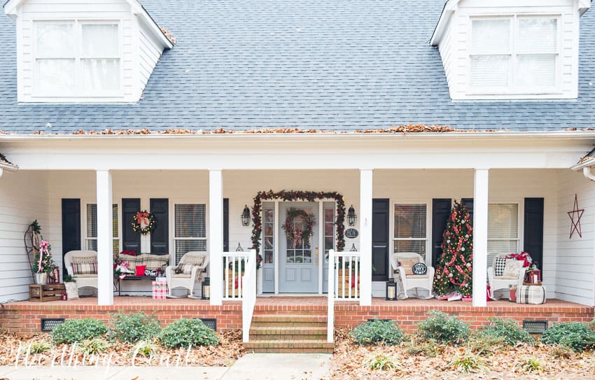 A large urban covered porch decorated in the farmhouse theme for Christmas.