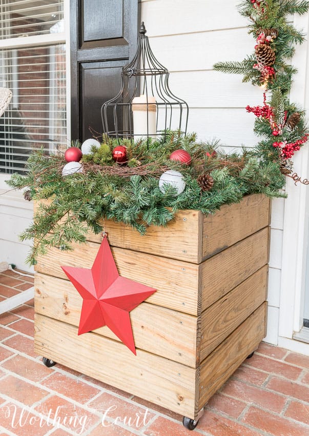 DIY wood planter decorated for Christmas with a red star.