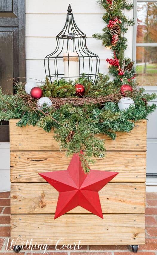 DIY rustic wood planter decorated for Christmas with red stars.