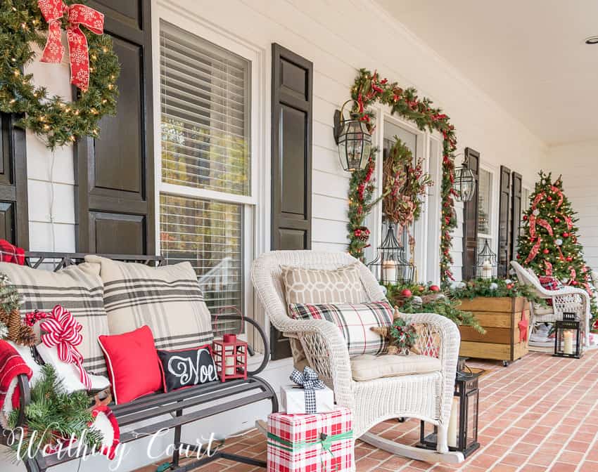 White wicker chairs with holiday throw pillows on the porch.