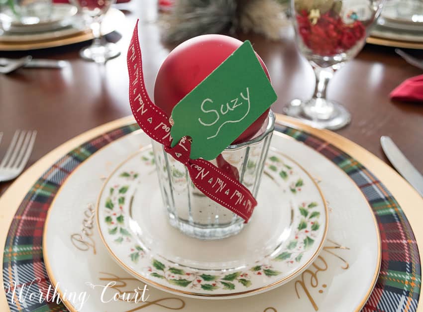 Votive place cards with a red ribbon and a tag that says Suzy.