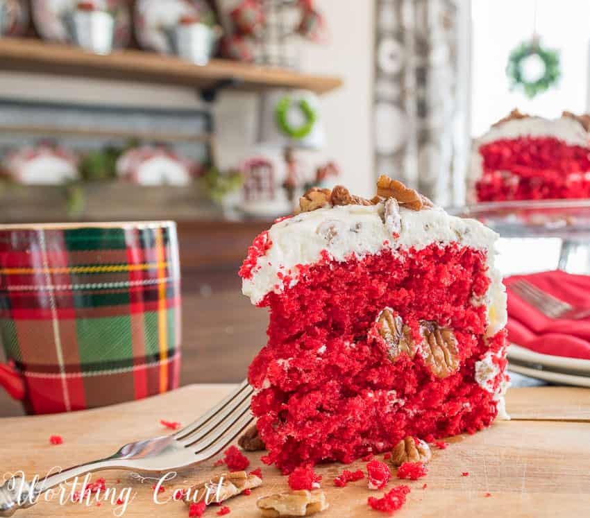 A slice of the cake is on the table revealing a bright red centre.