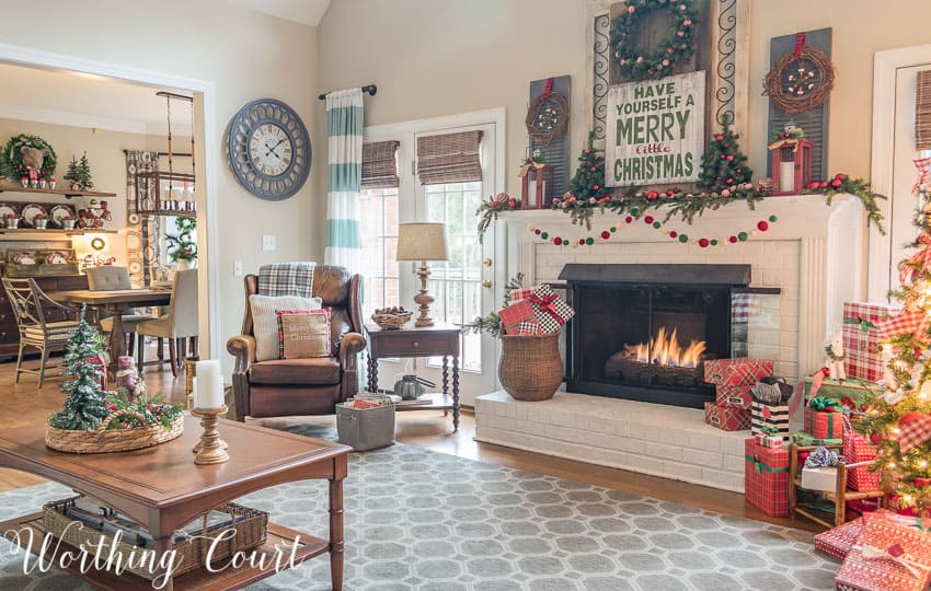 Christmas fireplace and cozy corner with pops of red and green Christmas decor.