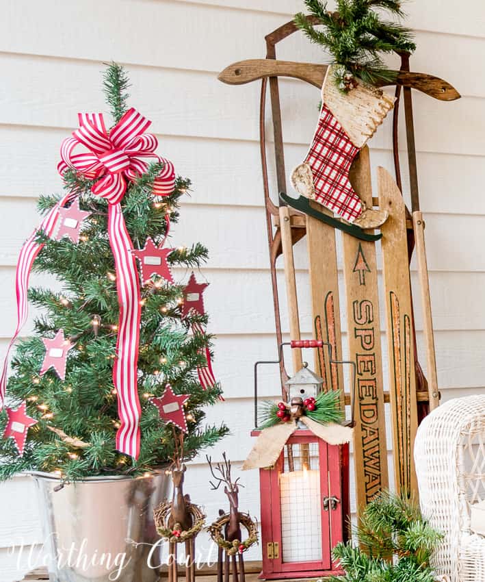 Vintage sled and small christmas tree on the front porch.
