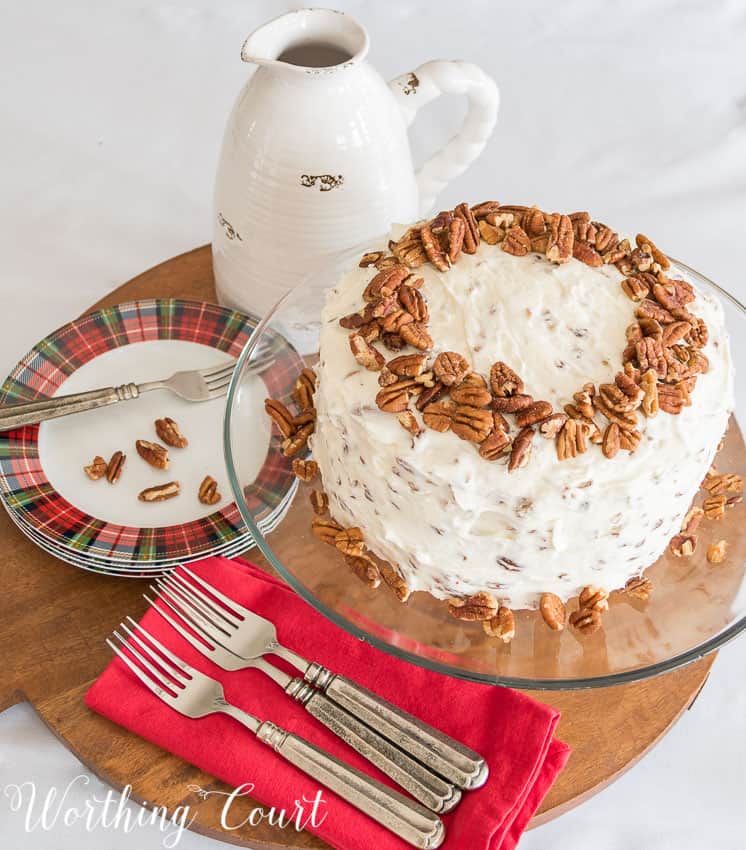 Recipe for classic red velvet cake with cream cheese icing and pecans on the top and side of the cake.
