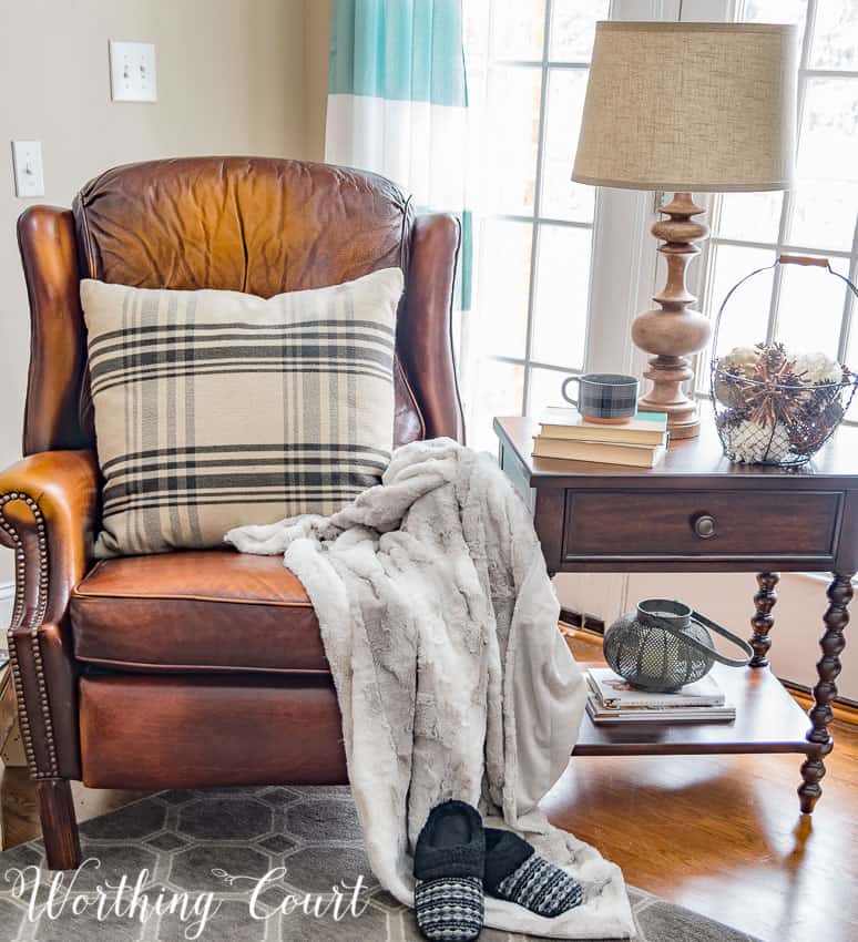 There is a faux fur throw on the armchair and slippers in front of it.