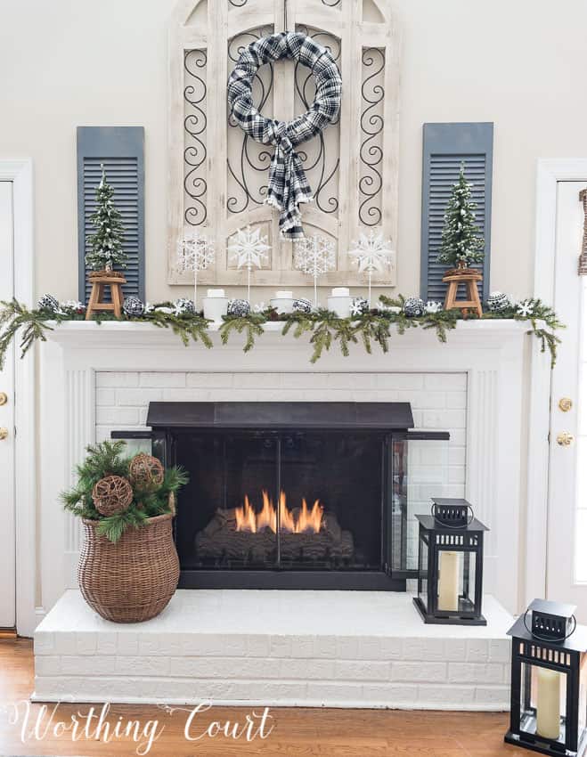 Painted red brick fireplace with winter decor.