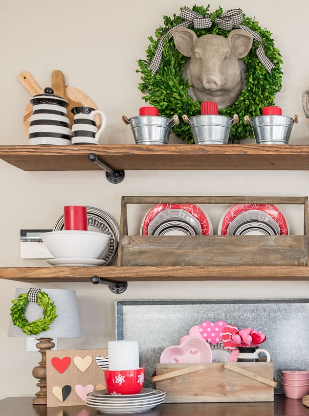 A wooden crate is on the sideboard with pink and red plates.