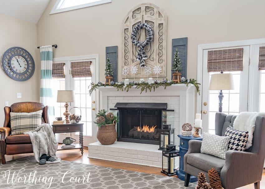 A white fireplace with two armchairs flanking it.