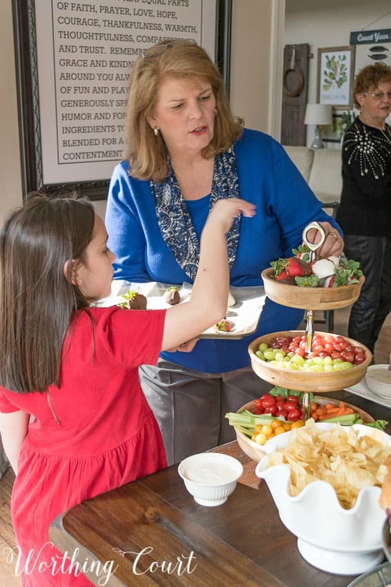 Suzy and granddaughter taking fresh fruit and vegetables from the table.