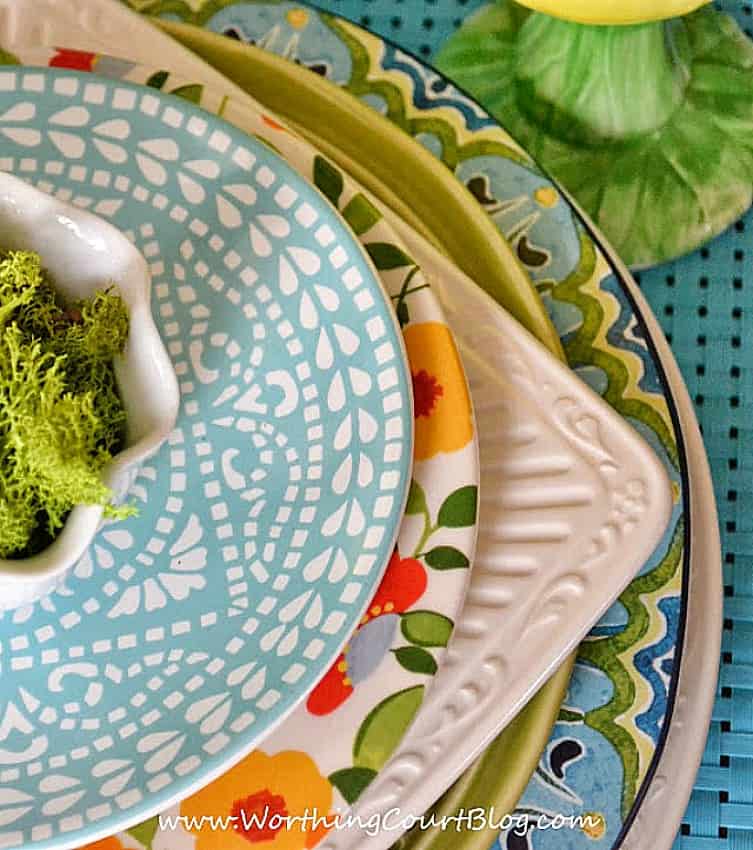 multiple colors of dishes stacked together for a spring tablescape